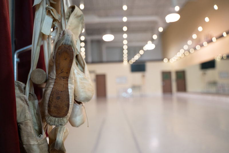 Ballet shoes hanging on ballet barre in dance Studio A